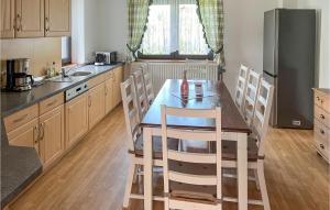 a kitchen with a table and chairs and a refrigerator at 4 Bedroom Awesome Home In Schnberg in Schoenberg