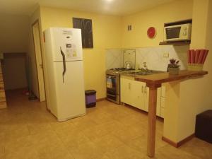 a kitchen with a white refrigerator and a counter at Casa Llao alojamiento de montaña in San Carlos de Bariloche