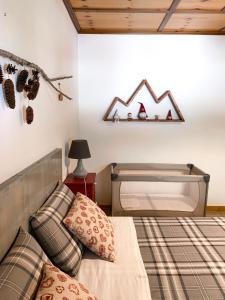 1 dormitorio con 1 cama y una ventana con un letrero de montaña en la pared en All'Ombra del Mortirolo, en Mazzo di Valtellina