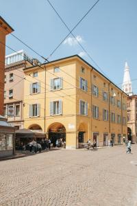um grande edifício amarelo numa rua de calçada em Molinari House Modena Rubino em Modena