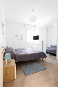 um quarto branco com uma cama e um espelho em Molinari House Modena Rubino em Modena