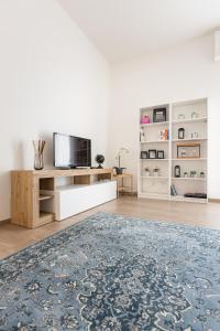 uma sala de estar com uma televisão e um tapete em Molinari House Modena Rubino em Modena