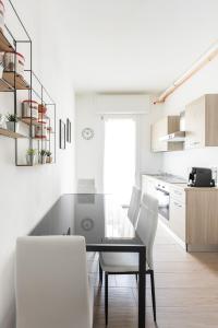 uma cozinha com uma mesa de jantar e cadeiras brancas em Molinari House Modena Rubino em Modena