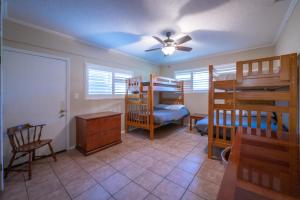 a room with bunk beds and a ceiling fan at Guadalupe River Getaway - 140 Feet of Beautiful Waterfront! in New Braunfels