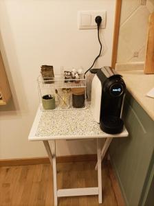 a small white table with a coffee maker on it at As Conchas in Vilagarcia de Arousa