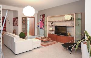 sala de estar con sofá blanco y TV en Amazing Apartment In Comiso With Swimming Pool, en Comiso