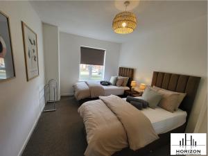 a hotel room with two beds and a chandelier at FREE Parking-Waterfront- Victoria Dock-Siemens-Contractors-Relocators in Hull