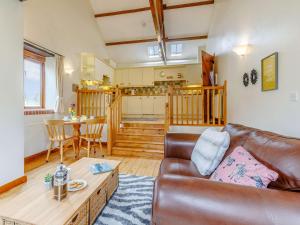 a living room with a leather couch and a table at 1 Bed in Holsworthy GBLUE in Sutcombe