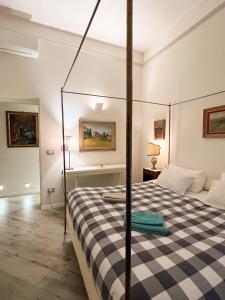 una camera con un letto con una coperta a scacchi in bianco e nero di casa Guido Reni a Bologna