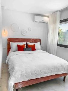 a bedroom with a large white bed with red pillows at Cozy & Brand New Flat In Casablanca in Casablanca