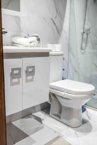 a white bathroom with a toilet and a shower at Cozy & Brand New Flat In Casablanca in Casablanca