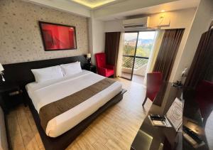 pokój hotelowy z łóżkiem i dużym oknem w obiekcie Venus Parkview Hotel w mieście Baguio