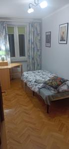 a room with a bed sitting on a wooden floor at Apartament VvGogh 4 pokoje in Rzeszów