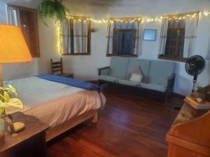 a bedroom with a blue bed and a couch at Glamping Teques Naturaleza de lujo Granja El Sol in Xoxocotla +16 photos