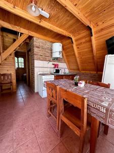 a kitchen with a table and chairs in a room at Hostería & Cabañas Río Fénix in Perito Moreno