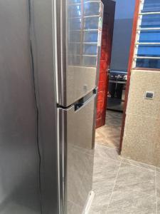 um frigorífico de aço inoxidável numa cozinha em Appartement meublé deux pièces em Agblangandan
