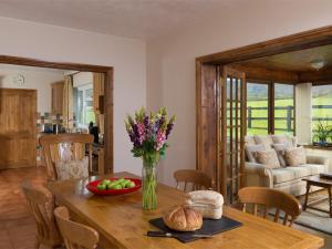 a dining room with a table with a vase of flowers at 3 Bed in Brecon Town BN037 in Llanspyddid +12 photos