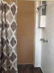 uma casa de banho com uma cortina de chuveiro e um WC em Los Huacales Apartamento em Oaxaca de Juárez