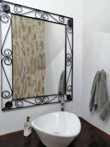 uma casa de banho com um lavatório branco e um espelho. em Los Huacales Apartamento em Oaxaca de Juárez