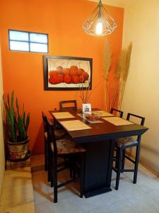 einen Esstisch mit Stühlen und ein Bild von Orangen in der Unterkunft Mejor precio ubicación 2p habitación cómoda in Mexiko-Stadt