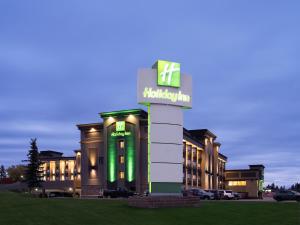 um hotel com um sinal verde em frente a um edifício em Holiday Inn Calgary Airport, an IHG Hotel em Calgary