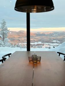 una mesa con lámpara y vistas a la nieve en Toppvillan - Ski In - Ski Out - 200 m till toppen och cykelleder en Järvsö