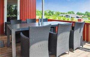 a dining table and chairs on a deck at Holiday Home Fiskervej Sydals Xii in Skovby