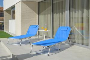 two blue chairs sitting on top of a patio at El Mirador de la Ribera - 7408 in Santiago de la Ribera