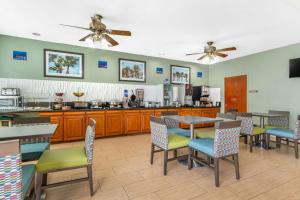 um restaurante com mesas e cadeiras e uma cozinha em Best Western Port Lavaca Inn em Port Lavaca