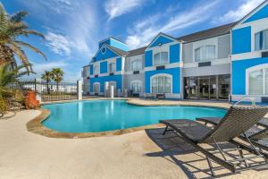 a swimming pool with two chairs and a building at Best Western Port Lavaca Inn in Port Lavaca