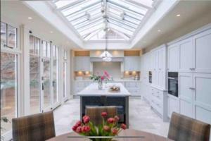 a large kitchen with white cabinets and a table and chairs at St Martin's House in Chichester