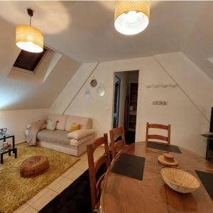 a living room with a table and a couch at Escapade à la Balluère in Tauxigny