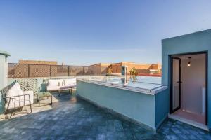 a balcony with a table and chairs on a building at Riad 2 chambres & Petit Déjeuner -Terrasse in Marrakesh