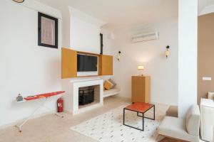 a living room with a fireplace and a tv on a wall at Riad 2 chambres & Petit Déjeuner -Terrasse in Marrakesh