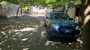 a blue car parked on the side of a street at Longboard Hotel in La Libertad