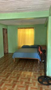 a bedroom with a bed and a wooden floor at Tico Room in Quepos