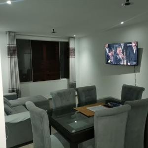 Chimor House في هوانتشاكو: غرفة معيشة مع طاولة وتلفزيون على الحائط