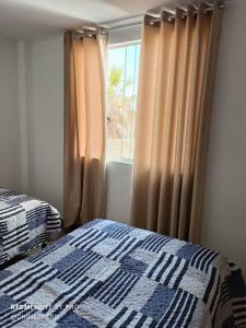1 dormitorio con 1 cama y una ventana con cortinas en Chimor House, en Huanchaco