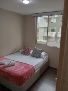 a bedroom with a bed and a window at Hermoso Apartamento en zona exclusiva in Armenia