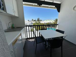 a kitchen with a table and a balcony with a view at appartement sur la Marina st François in Saint-François