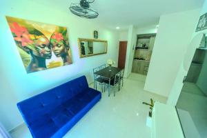 een woonkamer met een blauwe bank en een tafel bij Cozy/Exclusive 17th floor apartment with sea view in Cartagena