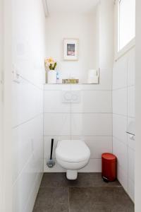 a white bathroom with a toilet and a window at Do Well Messe in Basel