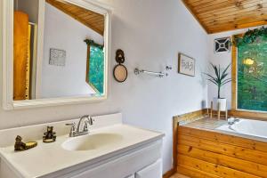 a bathroom with a sink and a mirror at NEW HOT TUB! Secluded 3 Bed Cabin in Pigeon Forge in Pigeon Forge +37 photos