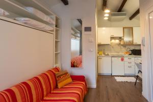 uma sala de estar com um sofá vermelho e uma cozinha em Casa Loredana em Veneza