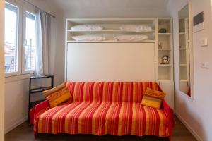 uma sala de estar com um sofá e prateleiras com almofadas em Casa Loredana em Veneza