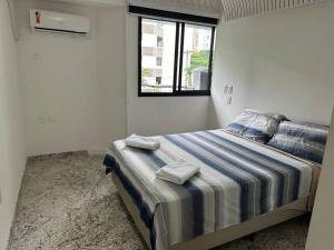 a bedroom with a bed with towels on it at Conforto e localização privilegiada na Pituba in Salvador
