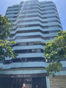 a tall building with a sign in front of it at Conforto e localização privilegiada na Pituba in Salvador