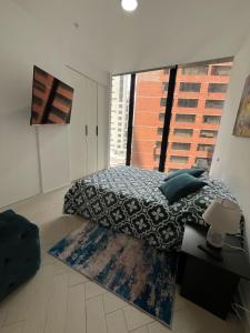 een slaapkamer met een bed en een groot raam bij Suite Piscina in Quito