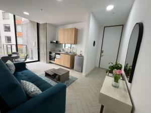 een woonkamer met een blauwe bank en een keuken bij Suite Piscina in Quito