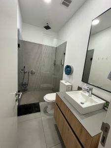 een badkamer met een wastafel, een toilet en een spiegel bij Suite Piscina in Quito